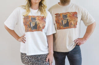 Woman and man wearing t-shirts with artwork titled Here Without You by Laura J Stratton